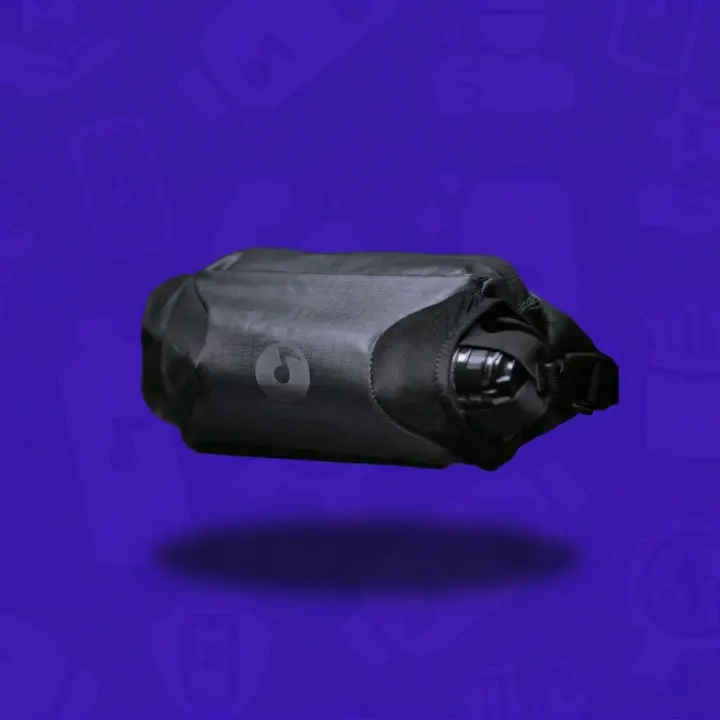 Black Lunchbox Sling Pack with an insulated bottle pocket on a purple background